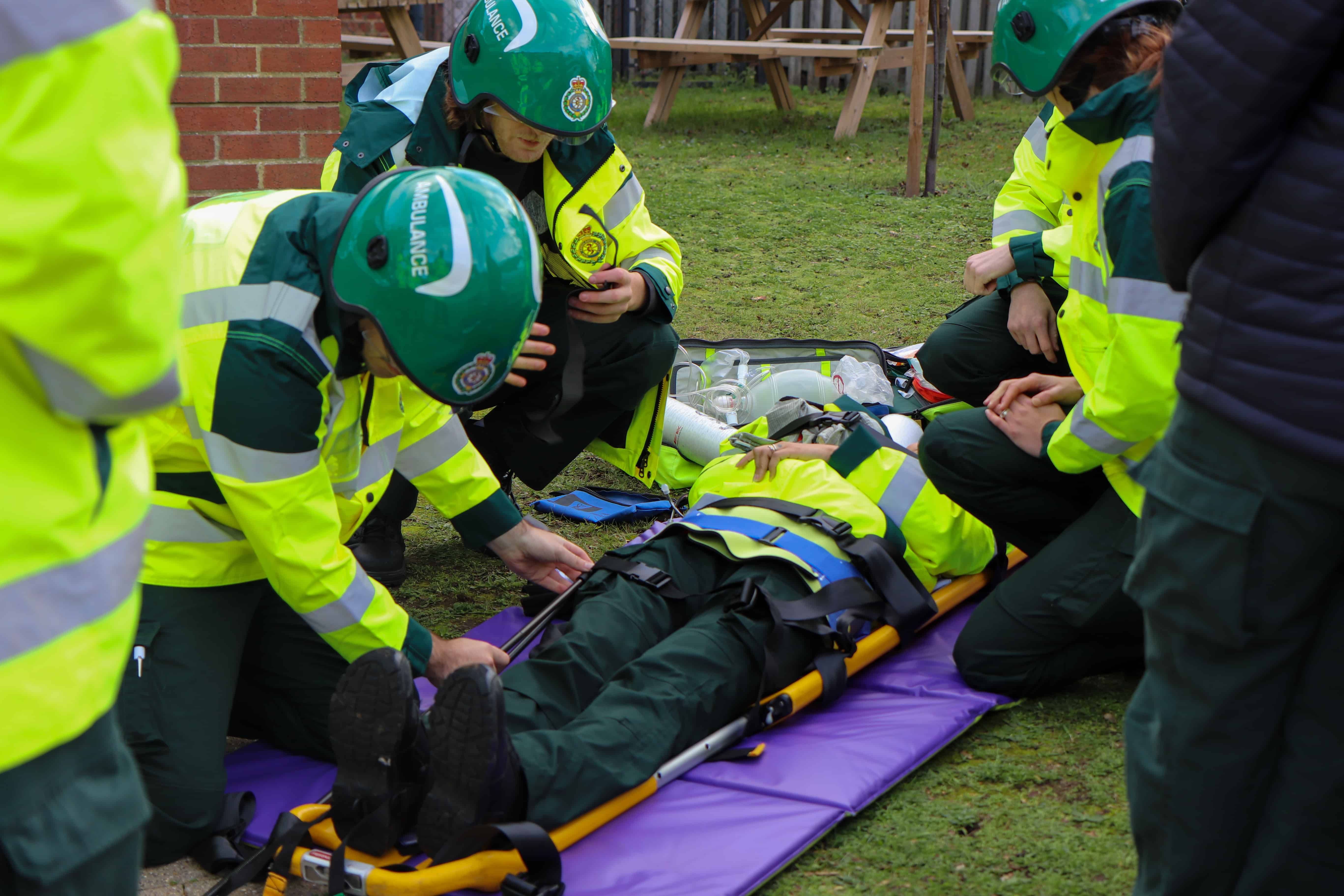 Ambulance apprentices practicing trauma scenarios involving a stretcher