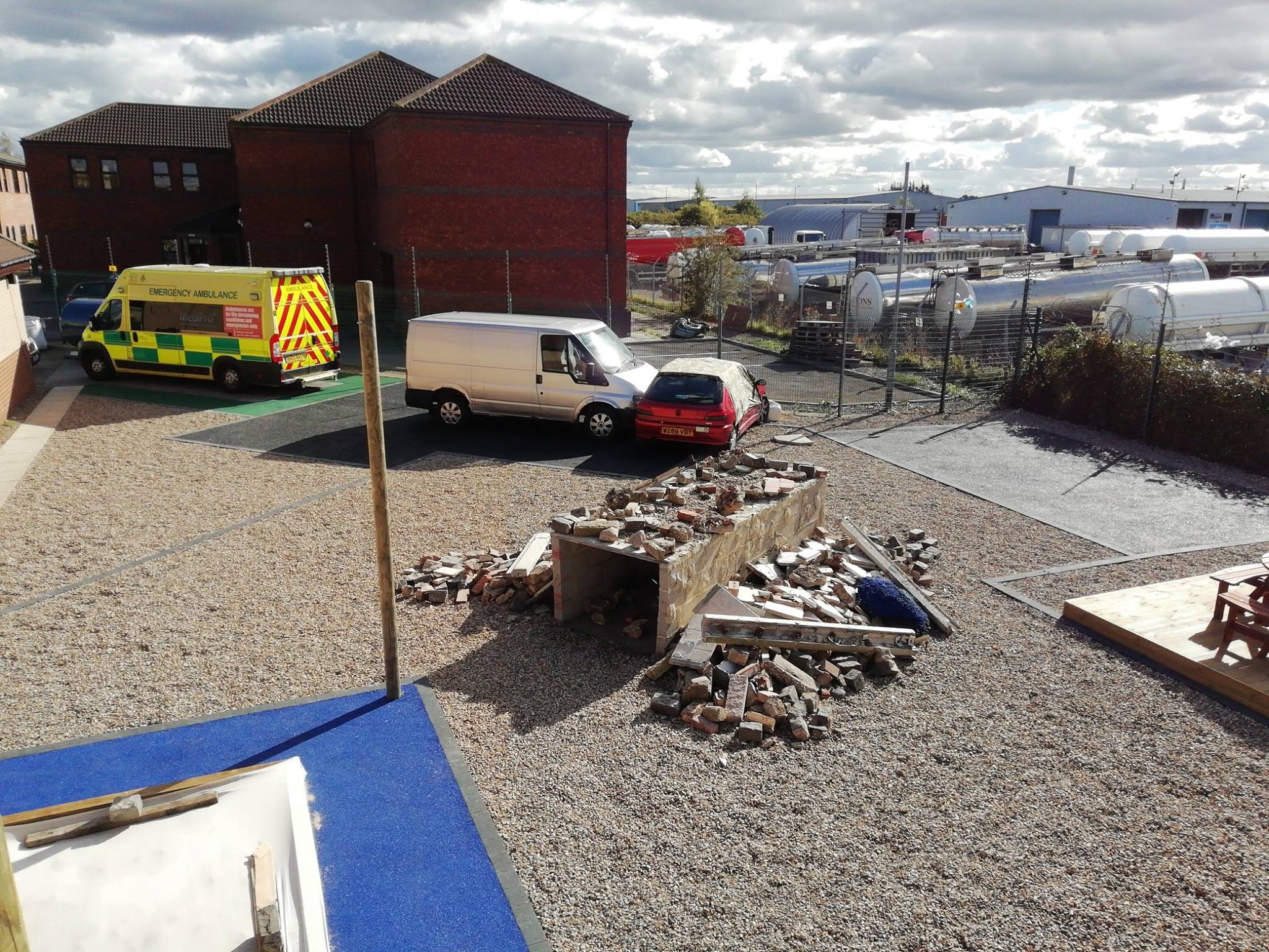 Scrap vehicles and Medipro ambulance in the outdoor training area at Faraday House